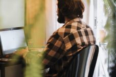 woman in black and white plaid long sleeve shirt sitting on chair