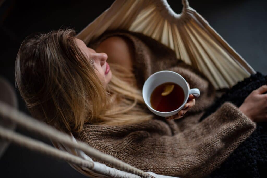 A Relaxed Break Scene: - woman on hammock holding cup of coffee